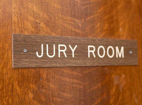 Jury room sign on wooden door.