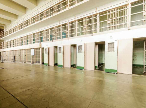 Empty prison cells in a hallway.
