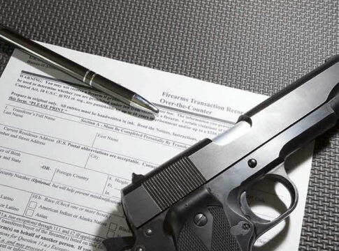 Form with gun and pen on table.