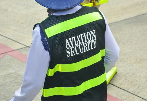 aviation security officer in high-visibility vest on airport tarmac