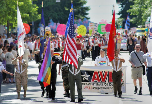 Parade with flags and AVER Puget Sound banner.