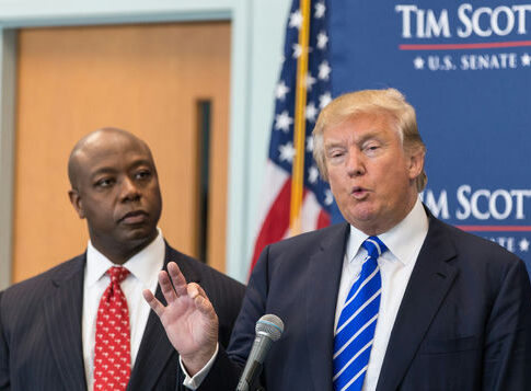 Two men in suits at a podium during a press event