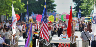 Parade with flags and AVER Puget Sound banner.