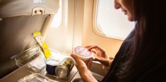 Passenger examining food items on an airplane tray table