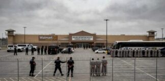 Law enforcement officers and detainees outside a secure detention facility at a Walmart location