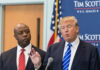 Two men in suits at a podium during a press event