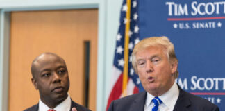 Two men in suits at a podium during a press event